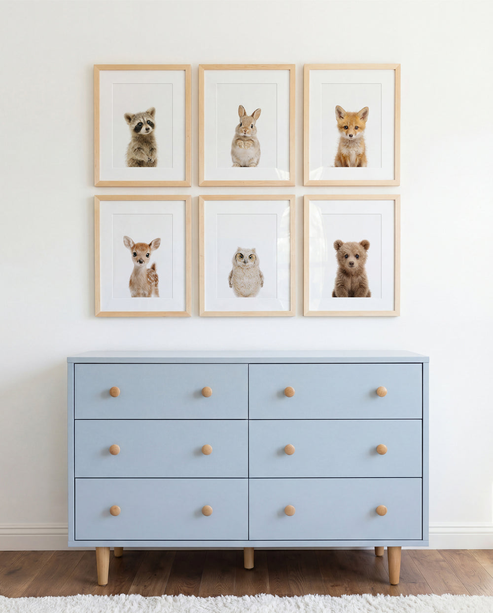 Light blue dresser with wooden drawers below framed animal prints on a white wall. | The Crown Prints