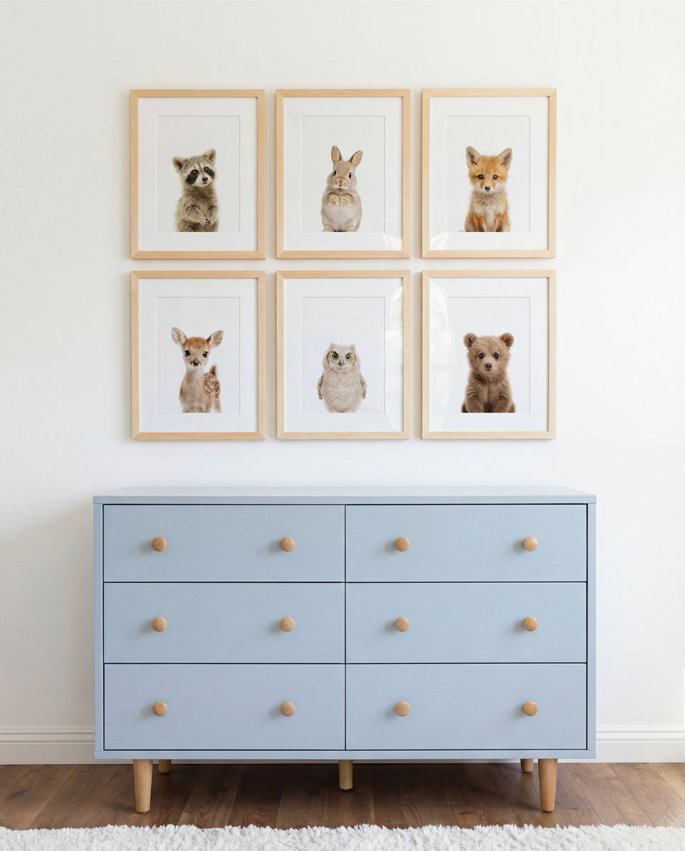 Framed woodland animal print above nursery dresser