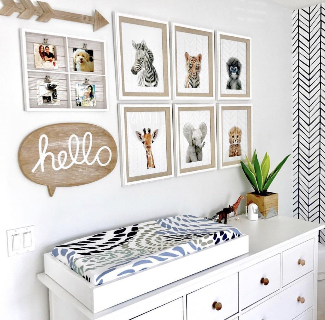Jungle and Safari Animal Prints hanging on a wall in a modern nursery room above a changing table